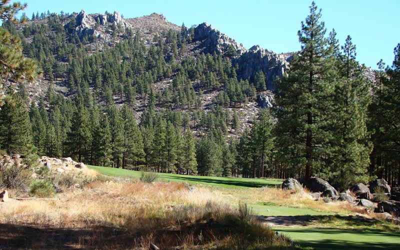 A towering rock formation serves as the backdrop to the tee ball before the fairway swingsâ€¦.