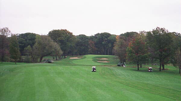 After a blind drive over a hill, the golfer is faced with a long approach to an elevated green that is well defended.