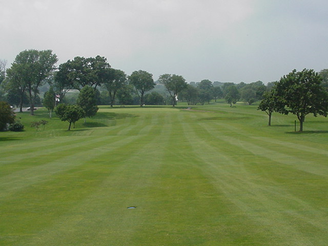 Tee shots on the closing hole should be down the right to stay in the fairway. The putting green is protected by the trees on the left.
