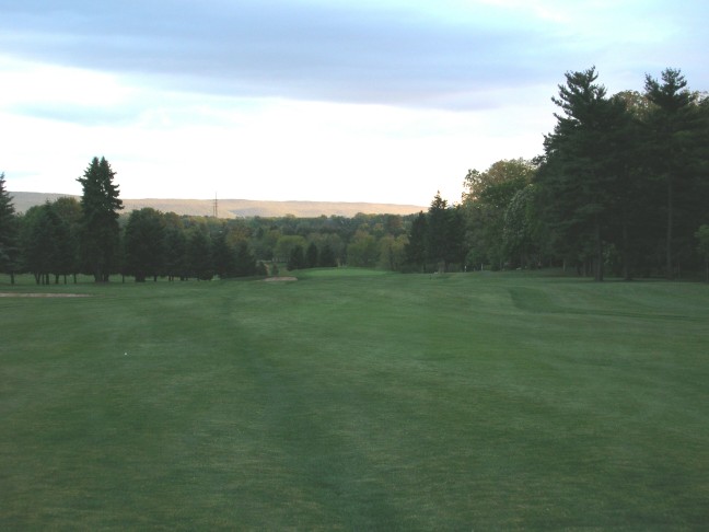 The long thirteenth hole at dusk, showing how much size the greens have lost. The original green stretched out to the edges of the green pad, which drops off twenty feet over the back and left.