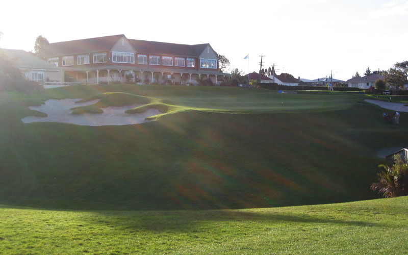 The par 3 seventh green, with the Clubhouse beyond.