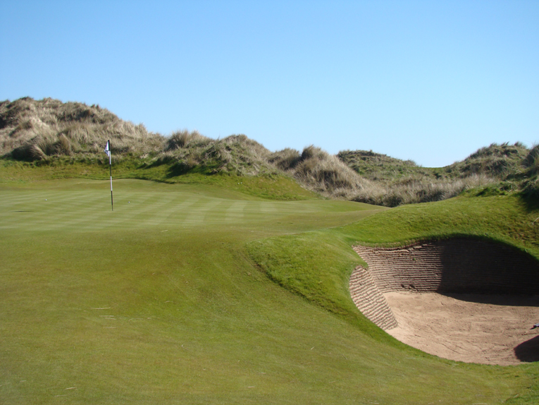 The bunkers are true hazards. Their steep revetted walls coupled with small concave floors conspire to make recovery difficult. Sometimes, play in the direction of the flag is not an option.